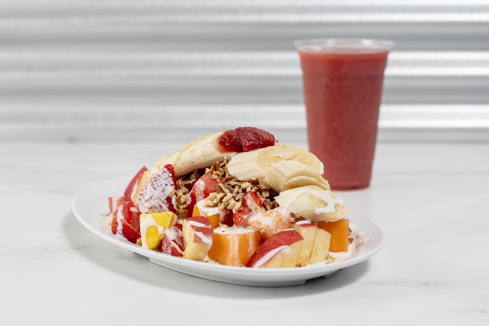 Biónico (fruit salad with granola pecan nuts and our signature sweet crema) with a Strawberry smoothie